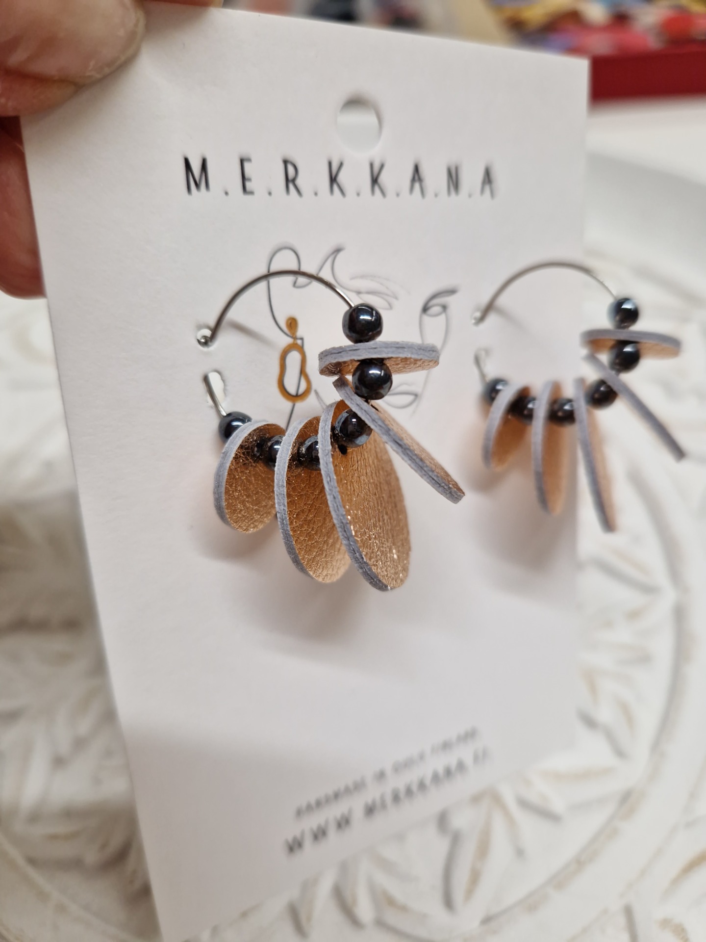 Kaunista ruusukultaa ja tummaa lasihelmeä kirurginteräsrenkaassa.