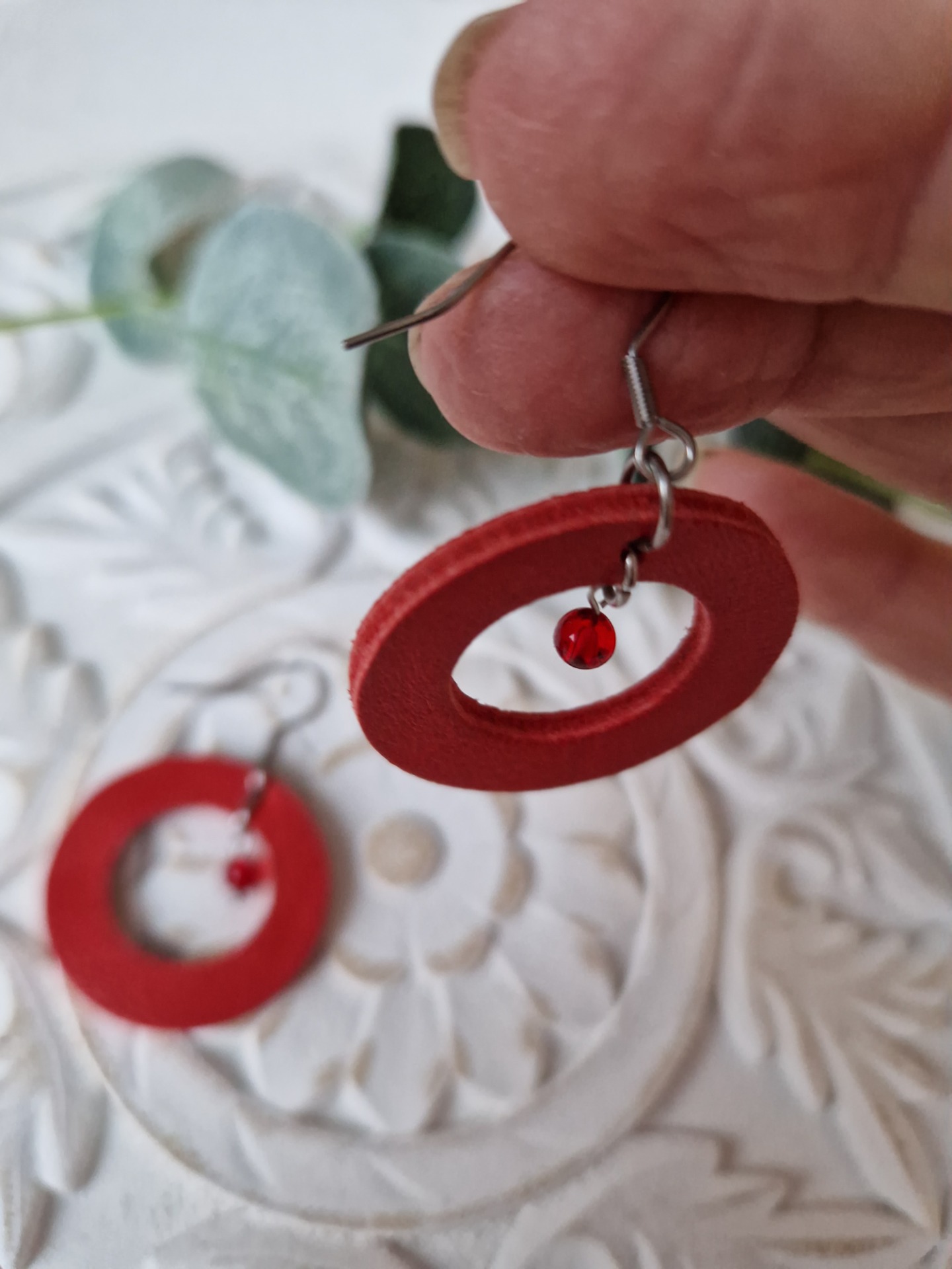 Rekaan keskellä on pieni punainen lasihelmi